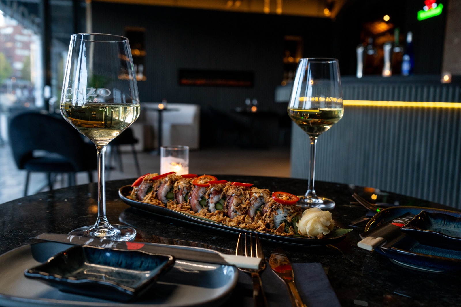 Sushi platter with Donzo branded wine glasses and cocktail bar