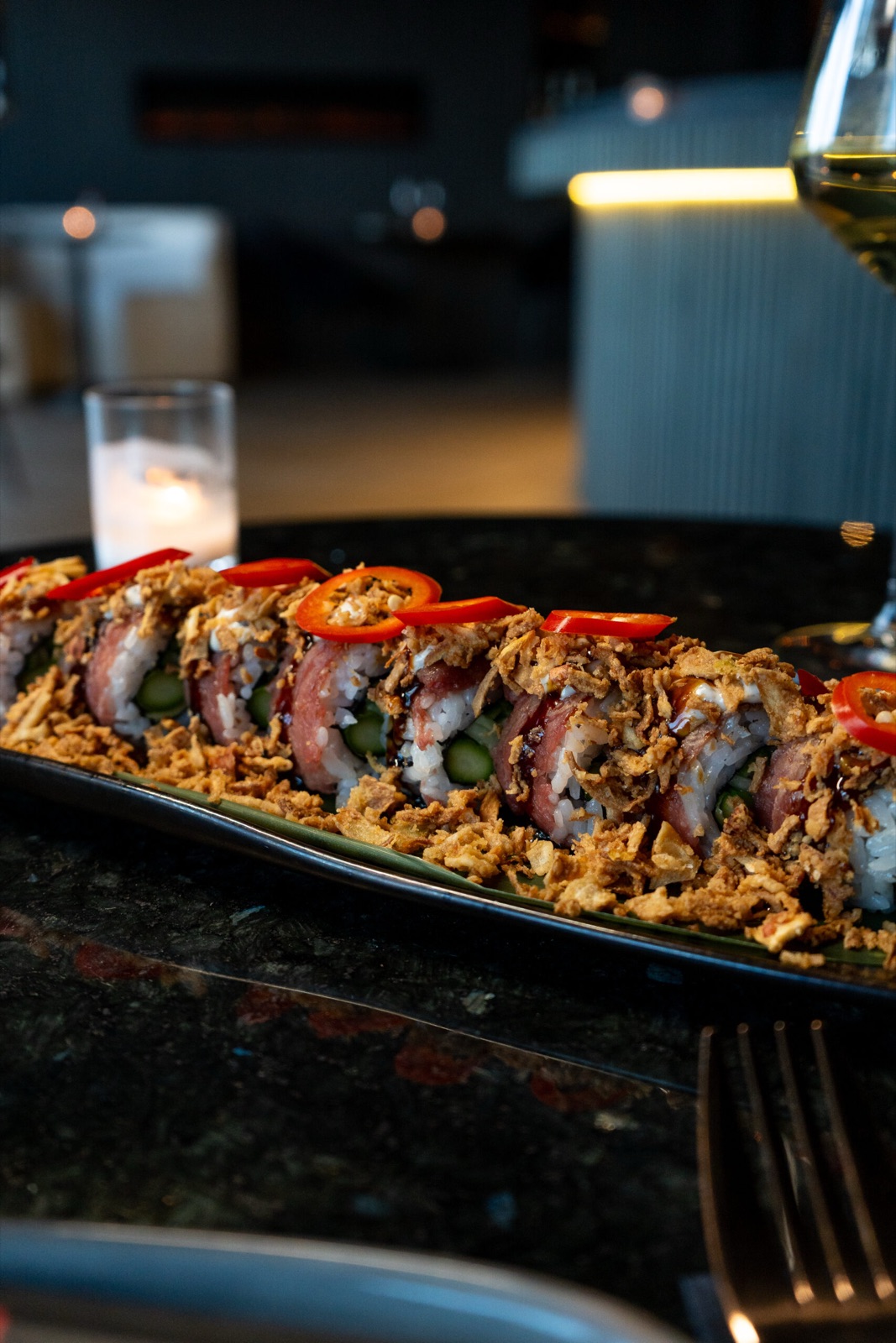 Atmospheric close-up of sushi roll with candlelight at Donzo