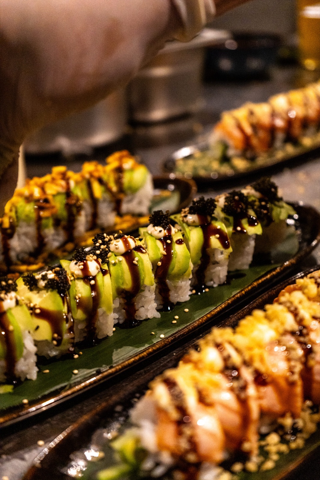 Multiple sushi roll varieties on dark marble table at Donzo Rotterdam Zuid